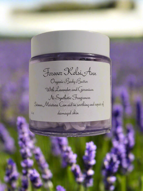 A jar of Forever Kelsi Ann organic 'Lavender and Geranium Infused Body Butter' with a field of lavender in the background.