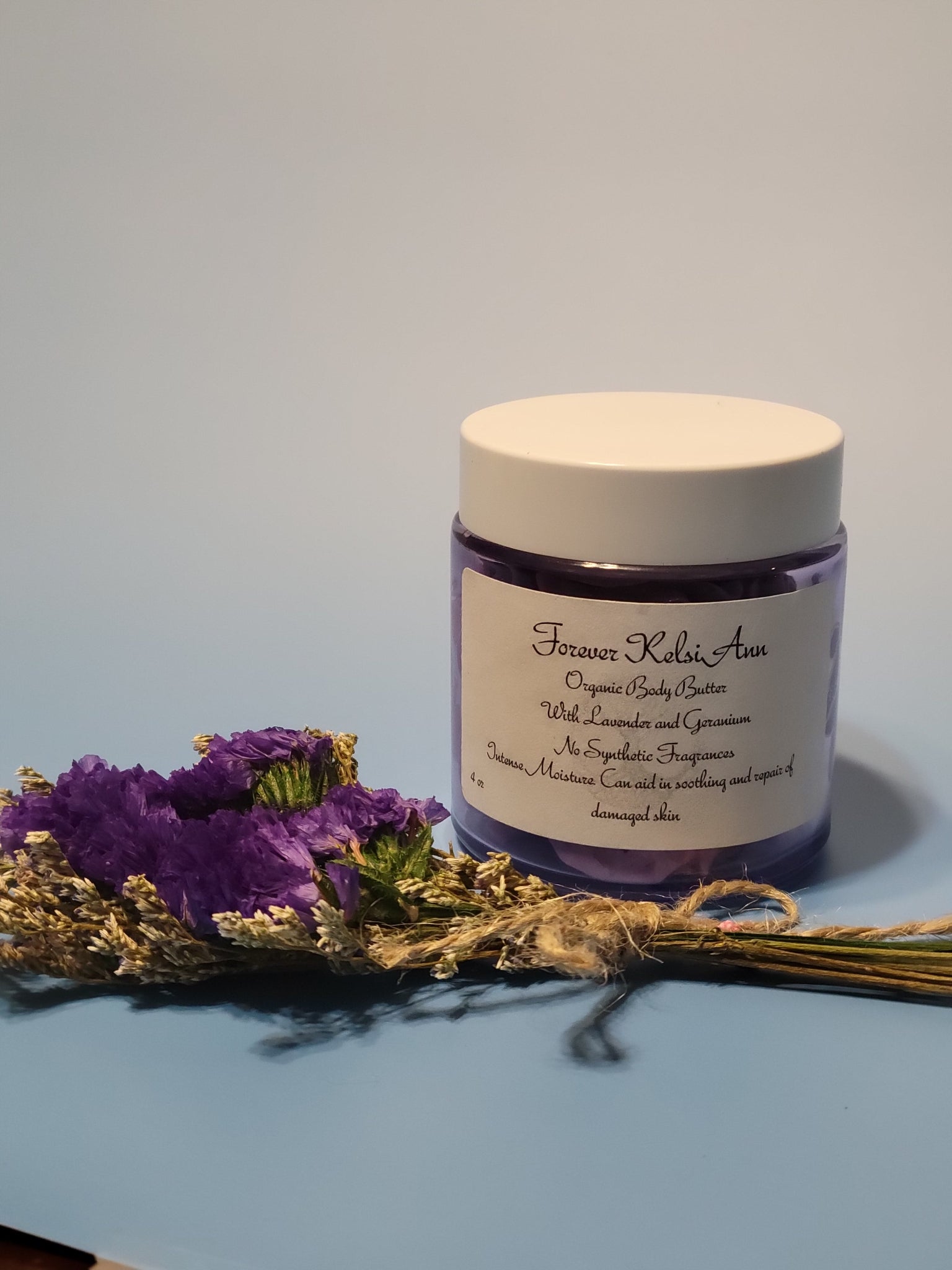Jar of Forever Kelsi Ann organic Lavender and Geranium body butter on a light blue background
